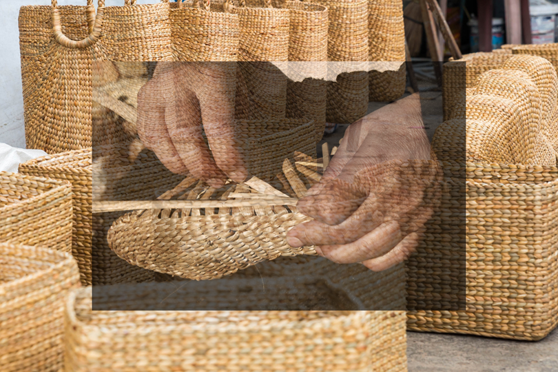 Perajin menganyam eceng gondok di tepi sungai